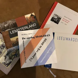 Verzameling tweedehands boeken over Nederlandse geschiedenis en cultuur, waaronder werken over Lemsterland en Leeuwarden
