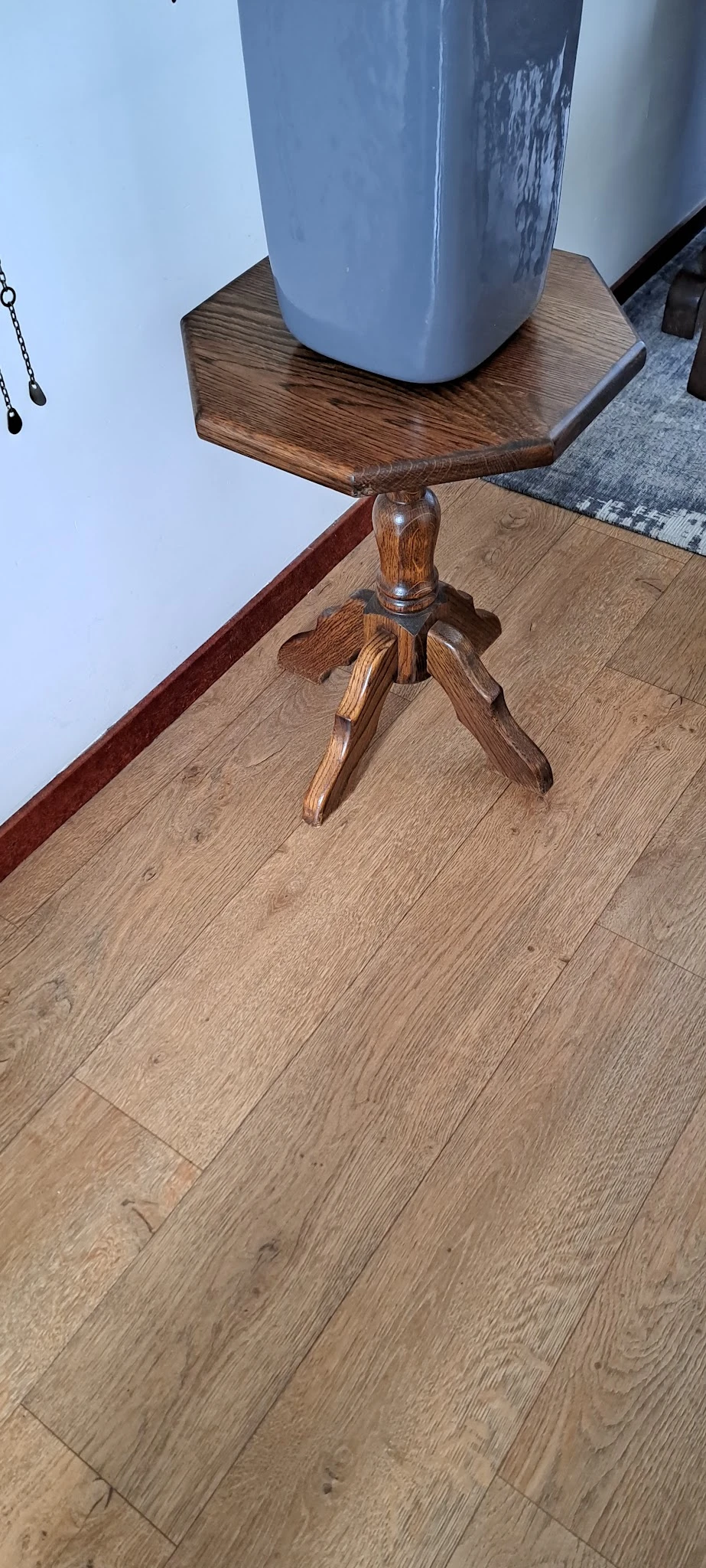 Houten staande lamp met drievoetige voet op houten vloer