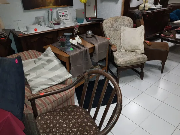 Winkelvloer met tweedehands meubels: fauteuils, stoelen en tafels uitgestald