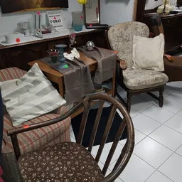 Winkelvloer met tweedehands meubels: fauteuils, stoelen en tafels uitgestald