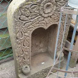 Stenen decoratief element met uitgewerkt bladmotief en uitsparing, mogelijk een tuinornament