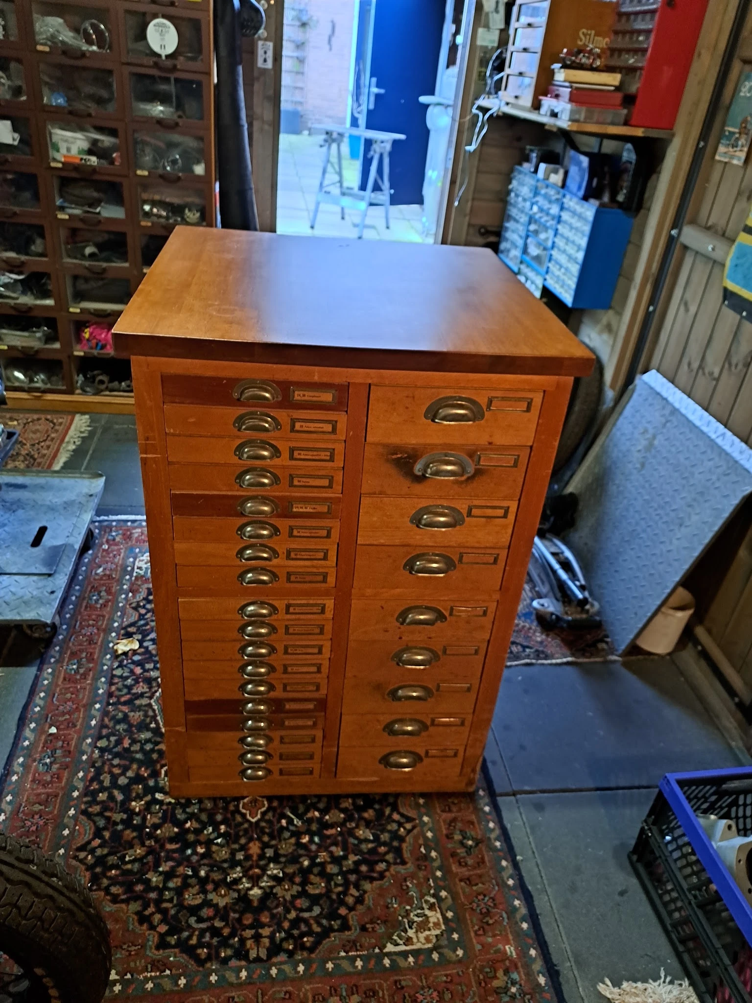Houten vintage apothecerskast met talrijke kleine laden en koperen handgrepen