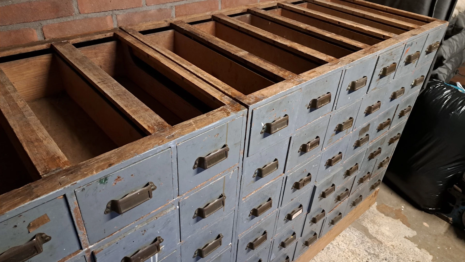 Vintage metalen archiefkast met meerdere laden en messing handgrepen, gedeeltelijk open