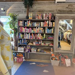 Boekenkast met kasten vol tweedehands boeken, spelletjes en media's in diverse kleuren
