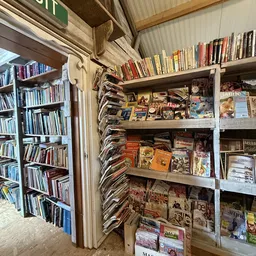 Rekken en stellingen met tweedehands cd's, dvd's en boeken in de kringloopwinkel