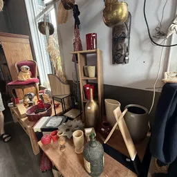 Vitrine met decoratieve items zoals vazen, beelden, kandelaars en huishoudartikelen in neutrale tinten