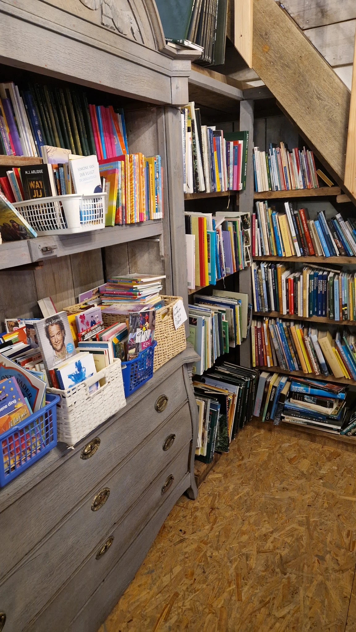 Boekenrekken en boeken in diverse genres, waaronder dvd's en cd's in opbergkuipen en kasten