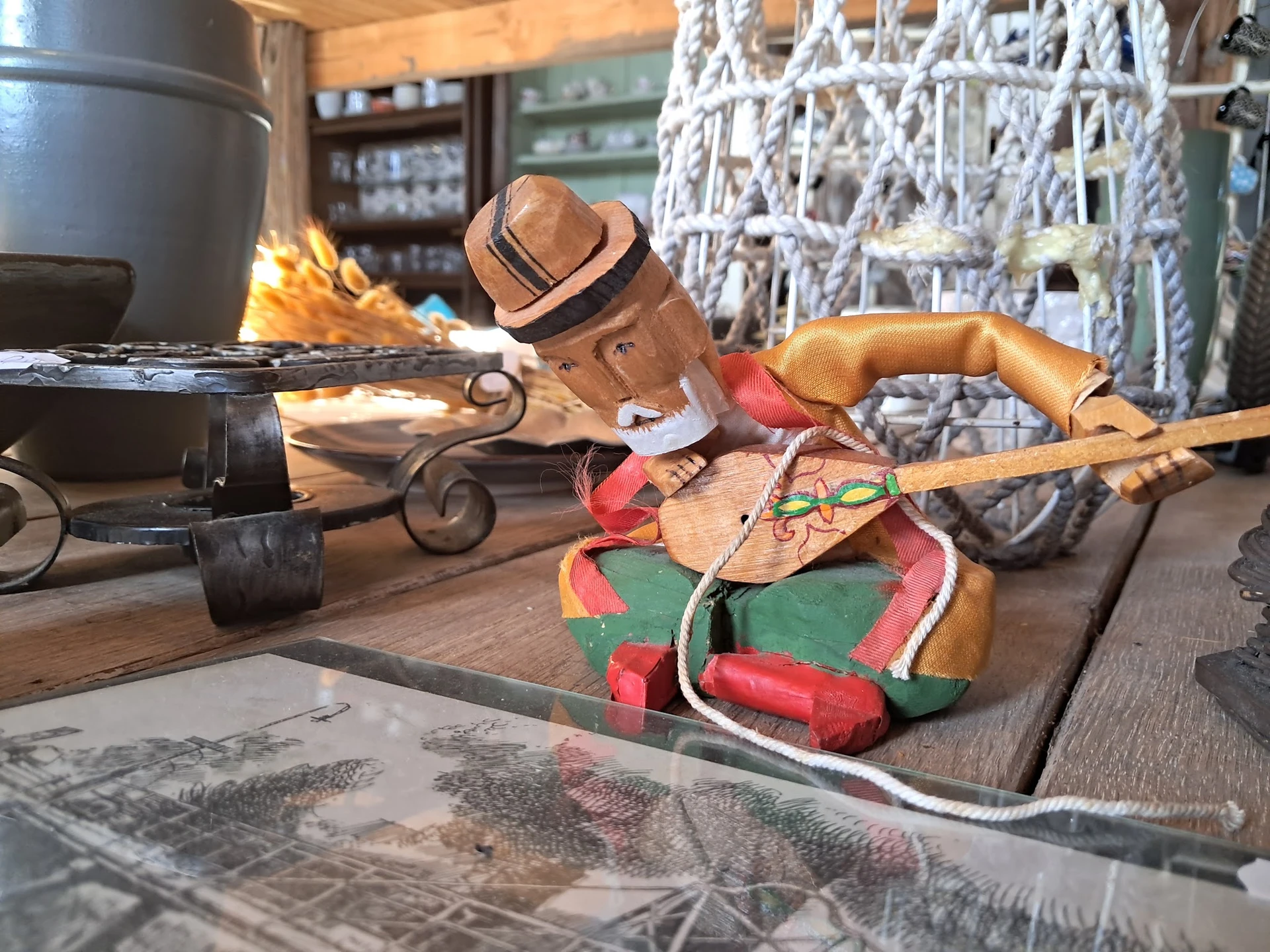 Diverse tweedehands voorwerpen op houten tafel, waaronder een houten vogel, skateboard en ander speelgoed
