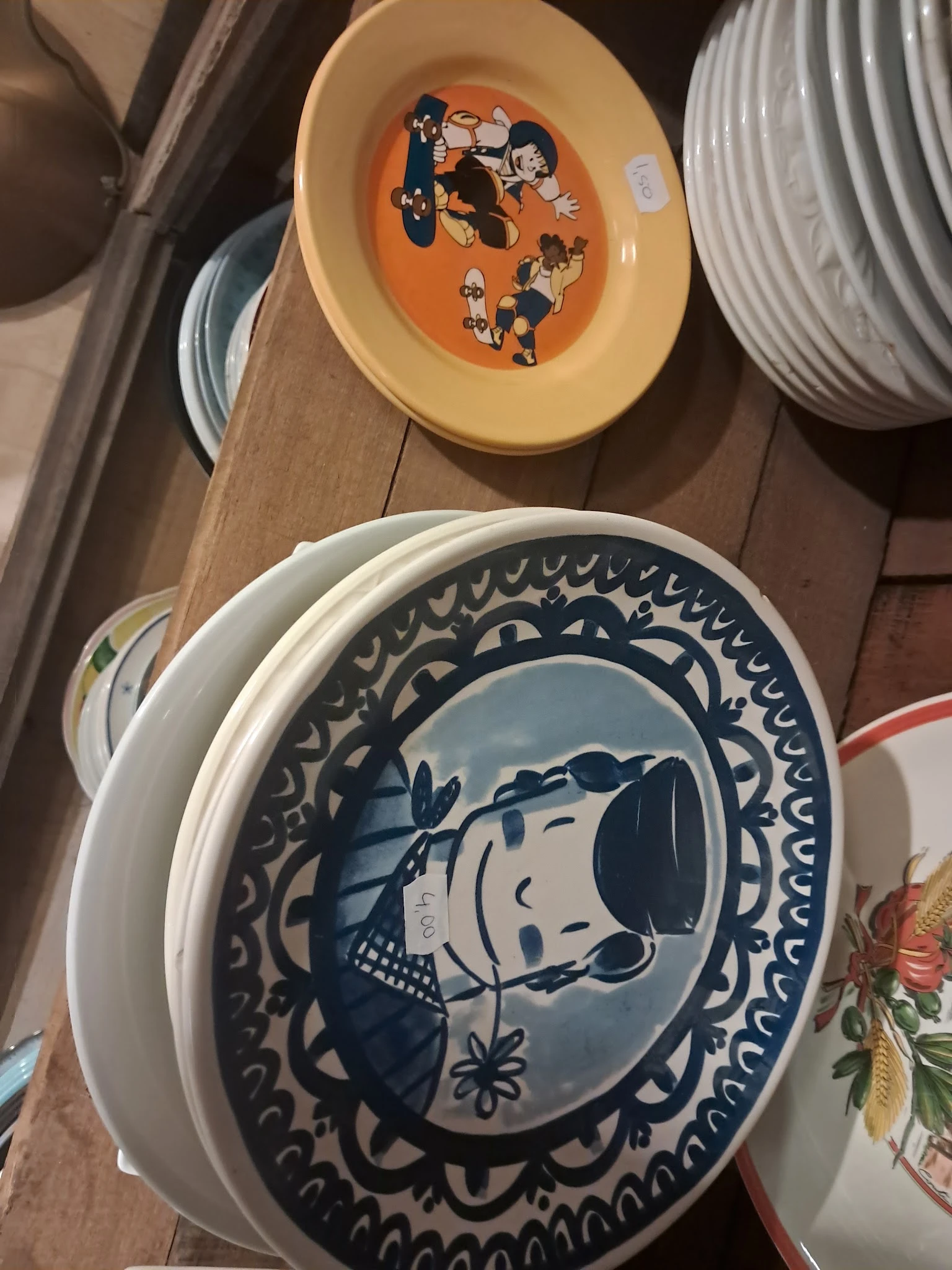 Blauw-wit servies met cartoonafbeelding, gestapeld op houten tafel