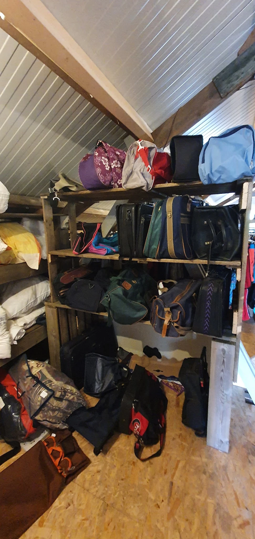 Houten stellingen met tassen, rugzakken en reisgoederen in verschillende kleuren