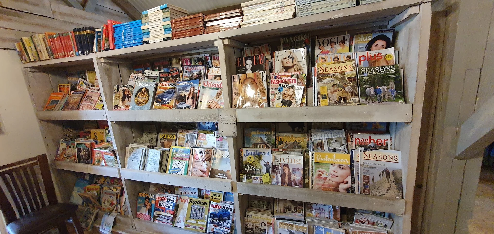 Stellingen met tweedehands boeken, dvd's en magazines op verschillende niveaus