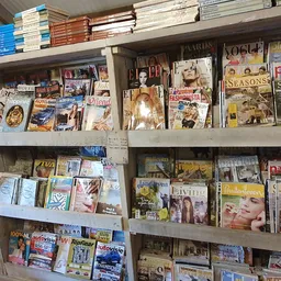 Stellingen met tweedehands boeken, dvd's en magazines op verschillende niveaus
