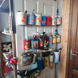 Wandrek met diverse huishoudartikelen en keukenspullen uitgestald op drie niveaus