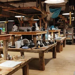 Ruim winkelbinnenland met houten tafels, stellingen met spullen en hangende decoratie