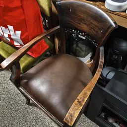 Bruine lederen stoel met houten armleuningen en decoratieve stiksel