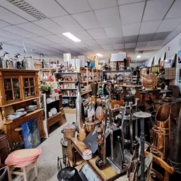 Overzicht van de winkelvloer met diverse tweedehands spullen, meubilair, muziekinstrumenten en huishoudartikelen op stellinge