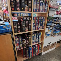 Houten stellingkast met uitgestalde puzzels en bordspellen in doosjes