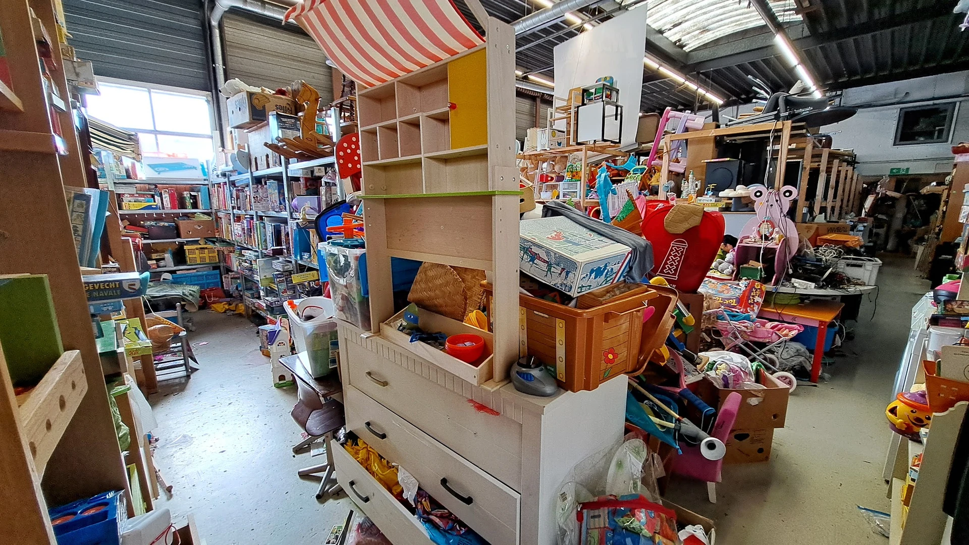 Winkelvloer met stellingen, meubels en diverse artikelen in kringloopwinkel