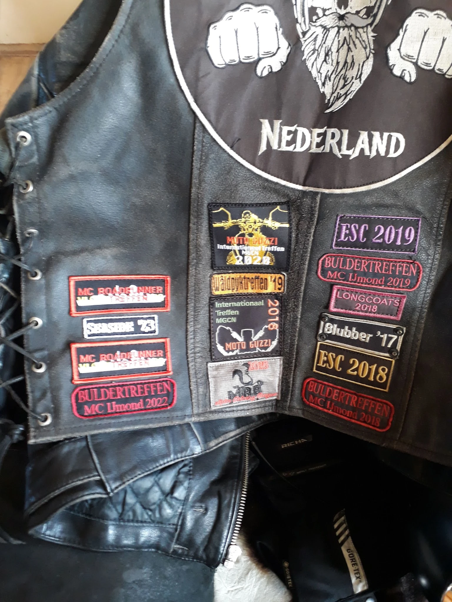 Zwart leren motorjack met patches en emblemen van motorclubevenementen