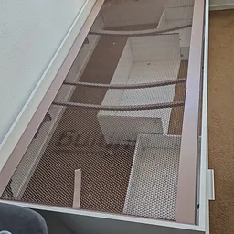 Binnenaanzicht van een kringloopwinkel met stellingen en mesh-schermen