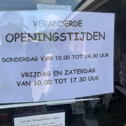 Openingstijden op een raam: donderdag 10.00-14.00 uur, vrijdag en zaterdag 10.00-17.30 uur