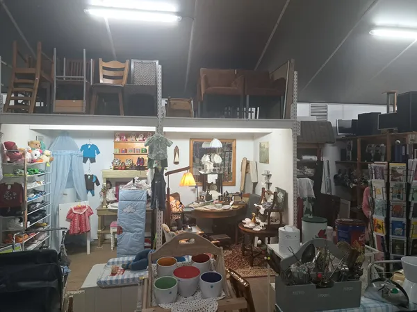 Vitrinekast met huisraad, meubels en decoraties in een kringloopwinkel