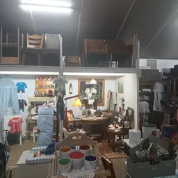 Vitrinekast met huisraad, meubels en decoraties in een kringloopwinkel