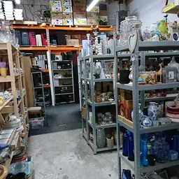 Winkelinterieur met stellingen vol huishoudartikelen, glaswerk, decoratie en diverse tweedehands spullen