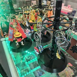 Uitgestalde sleutelhangers en souvenirs op een zwarte draaier in de winkel