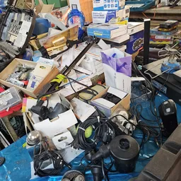 Verzameling van elektronische apparaten, kabels en accessoires op een blauwe ondergrond
