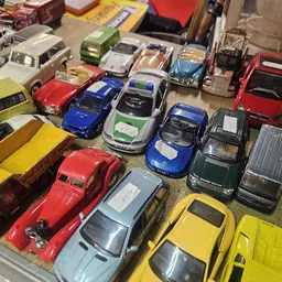 Verzameling speelgoedautootjes in verschillende kleuren, netjes uitgestald op een tafel