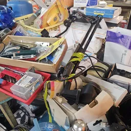 Verzameling elektronische apparaten, gereedschap en diverse spullen op werkoppervlakken