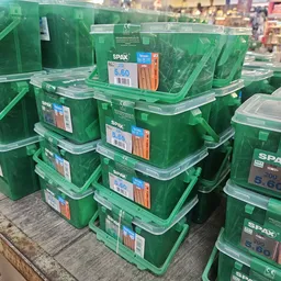 Groene plastic opbergboxen met deksels gestapeld op een tafel, elk met een prijskaartje
