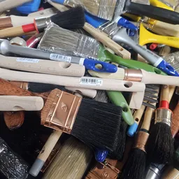 Verzameling tweedehands schilders- en verfgereedschap zoals kwasten, verfrollers en verfblikken