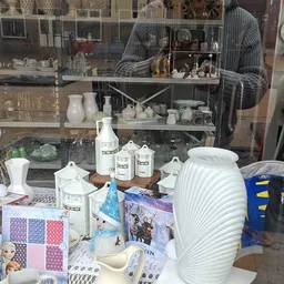 Uitgestalde huishoudelijke artikelen en toiletartikelen in een kringloopwinkel