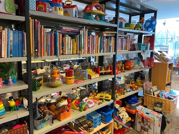 Stellingen vol met boeken, speelgoed, huishoudartikelen en diverse secondhandartikelen in een kringloopwinkel