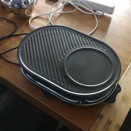 Elektrische grillplaat met twee verwarmingsvlakken op houten tafel