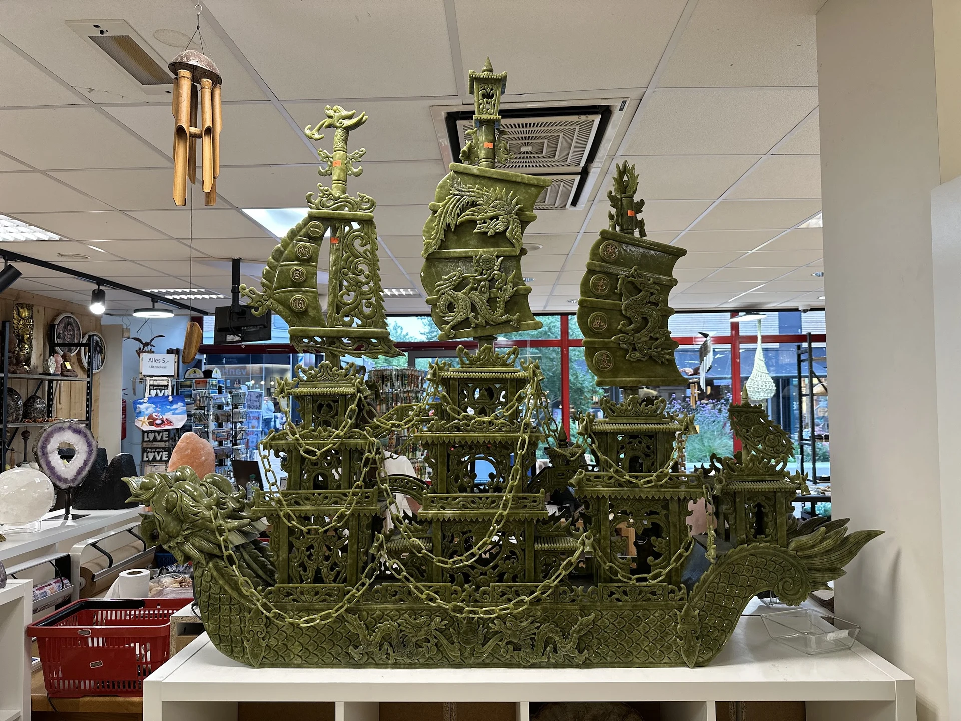 Groene decoratieve scheepsmodel met torens en ornamentale details op witte display plank