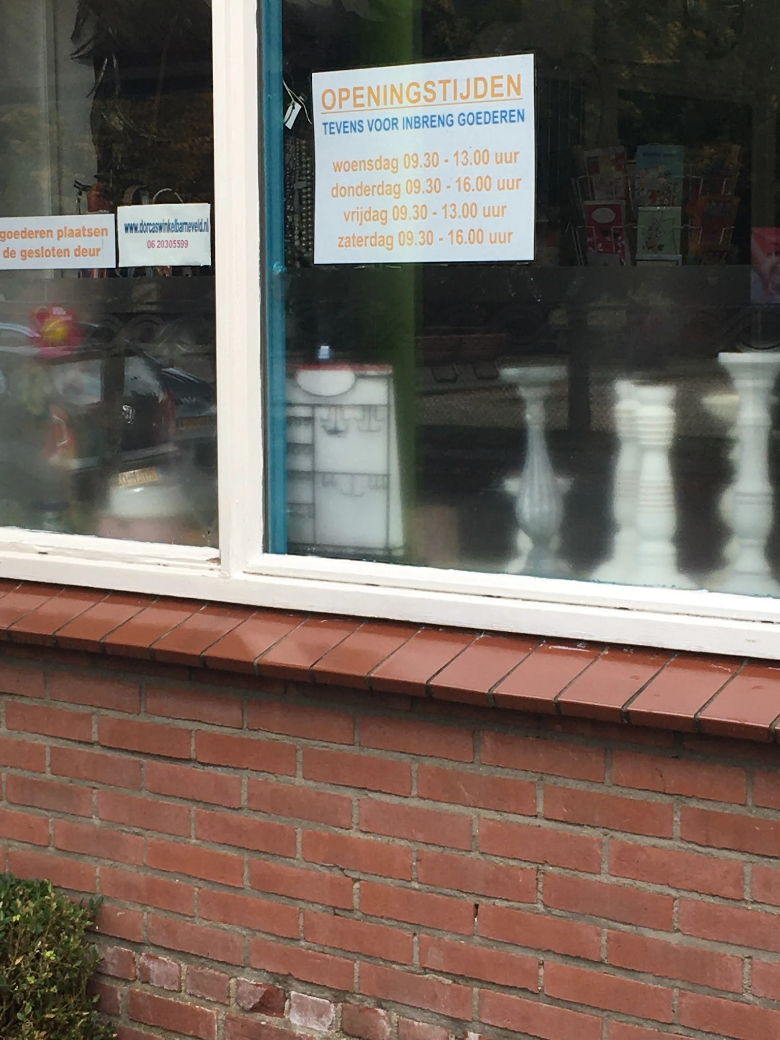 Winkelruit met witte schrijflijn en donkere etalage van kringloopwinkel