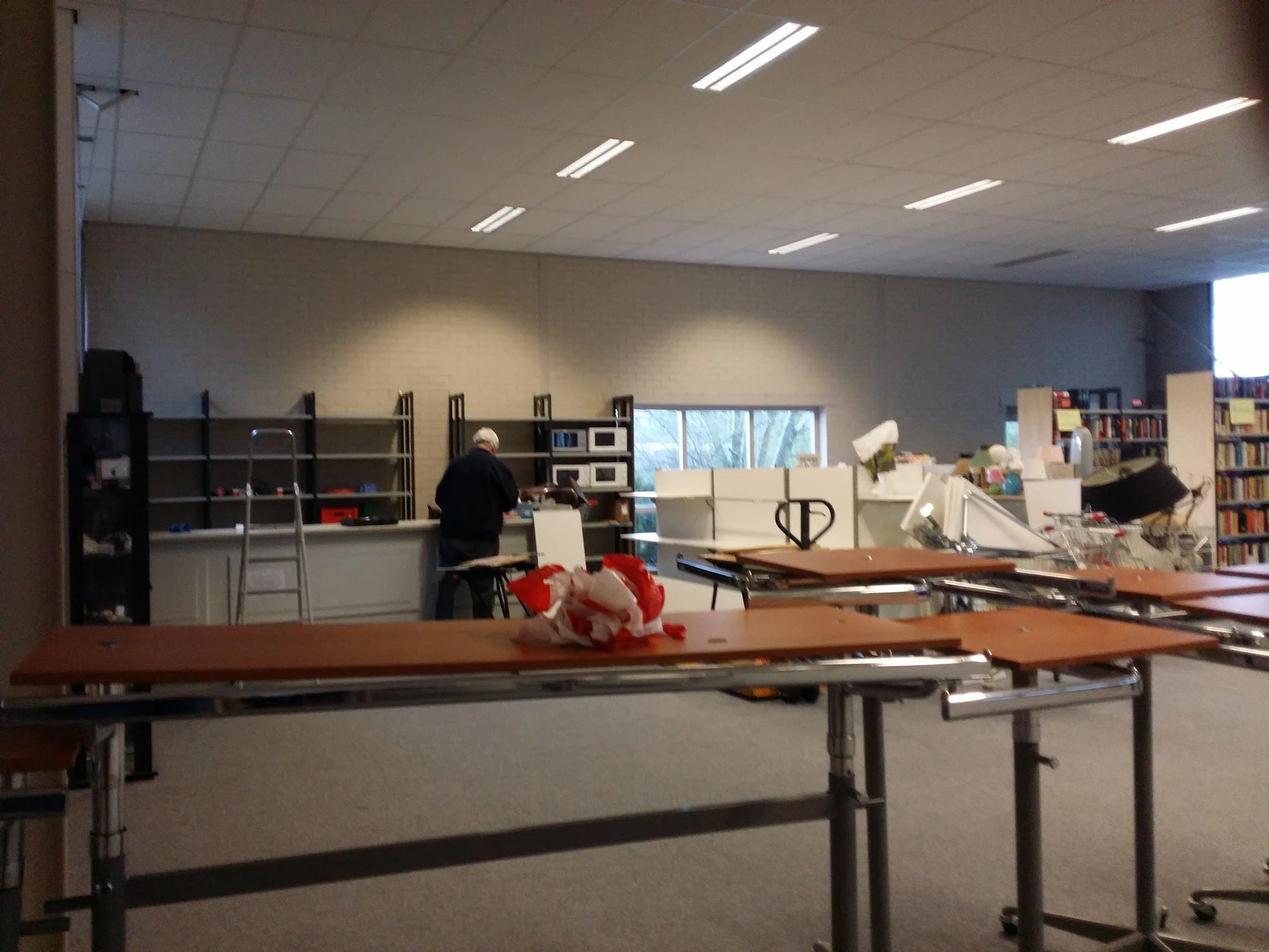 Winkelvloer met werktafels, boekenrekken en diverse artikelen in de winkel