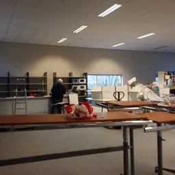 Winkelvloer met werktafels, boekenrekken en diverse artikelen in de winkel