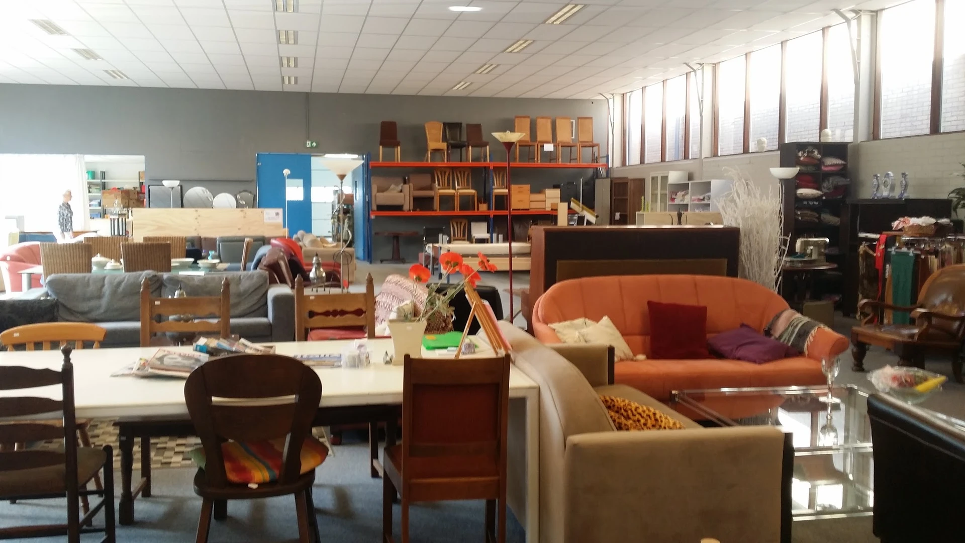 Winkelvloer met diverse meubels, boekenkast, zithoeken en huishoudelijke artikelen