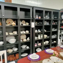 Glazen vitrinekast met serviesgoed, bordenwaar en decoratieve items uitgezocht naar waarde