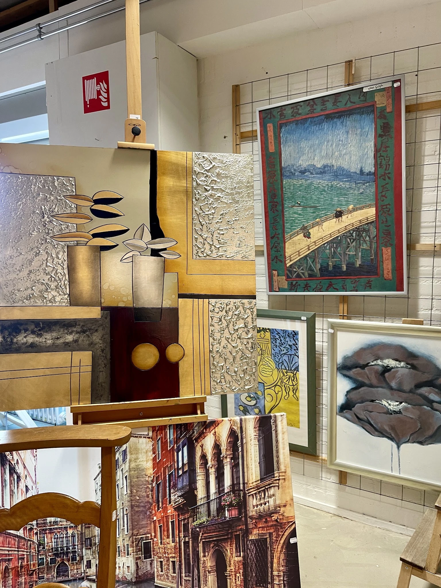Diverse kunstwerken en decoratiestukken waaronder schilderijen, prints, vazen en sculpturen op stellingen uitgestald