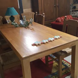 Houten eettafel met wicker stoelen en decoratieve objecten erop