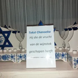 Displaykaart met Hebreeuwse tekst en Chanoeka-versieringen met kandelaars