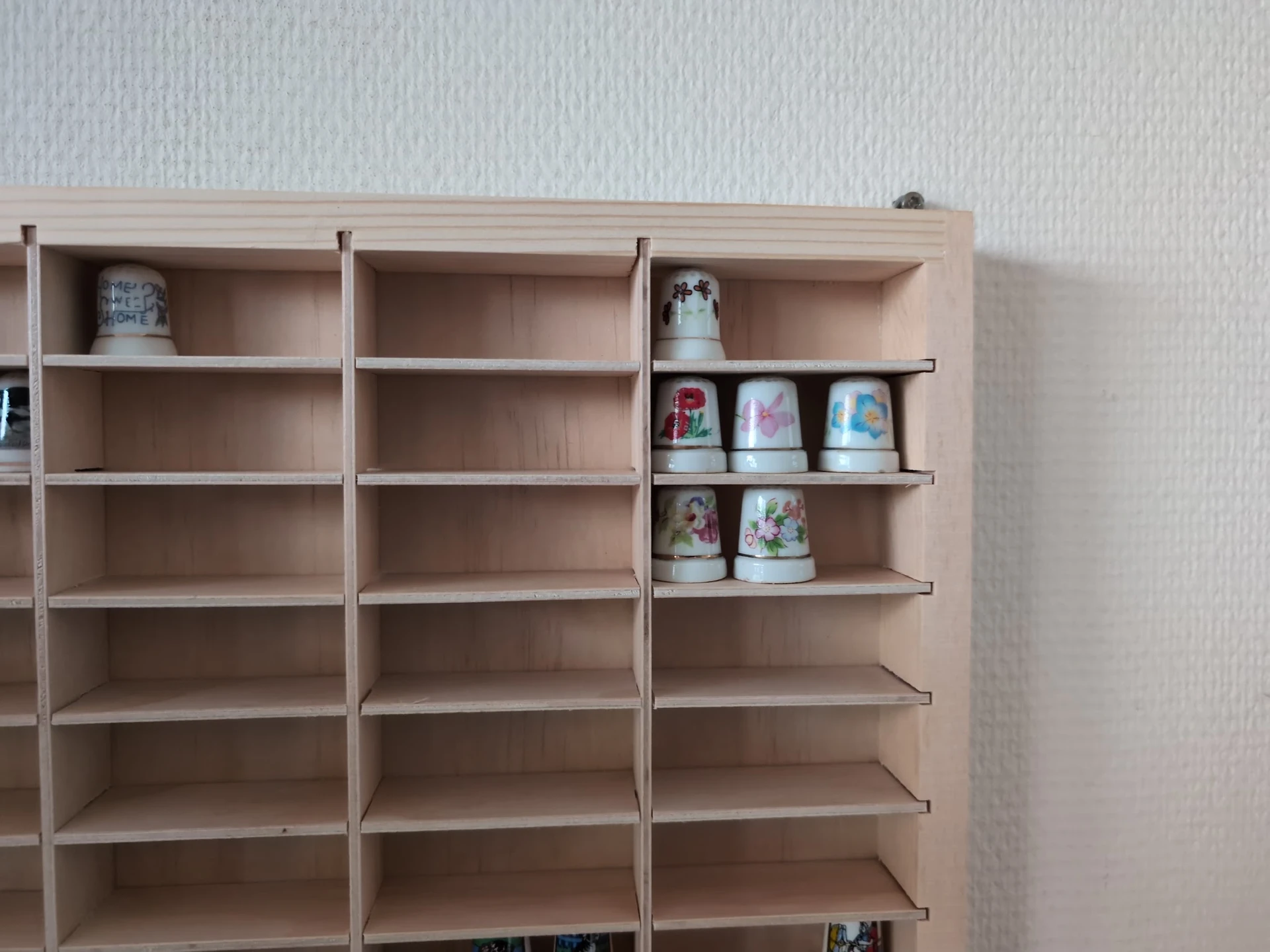 Houten wandkast met служба schappen waarop serviesgoed en decoratieve items zijn uitgestald