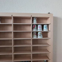 Houten wandkast met служба schappen waarop serviesgoed en decoratieve items zijn uitgestald
