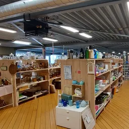 Winkelvloer met houten stellingen vol tweede-handsspullen en diverse huishoudartikelen