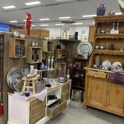 Uitgestalde huishoudelijke artikelen, servies, decoratie en meubelstukken in de kringloopwinkel